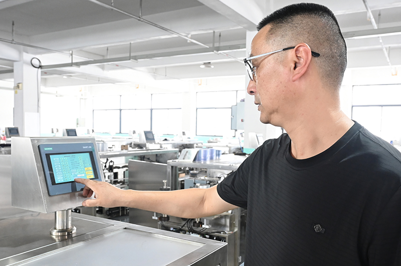 Un technicien de Finetech utilise une machine de remplissage et de scellage d'ampoules en plastique.