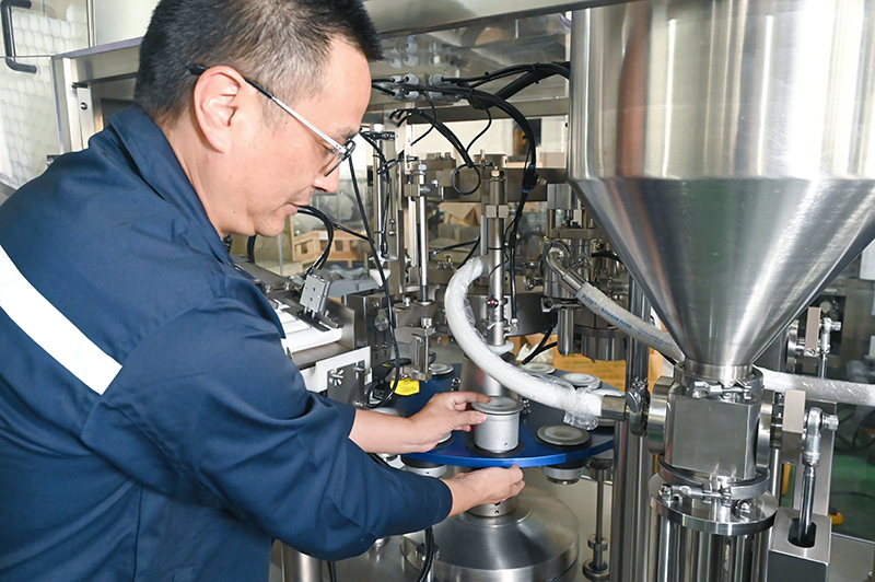 A technician is debugging the tube filling and sealing machine
