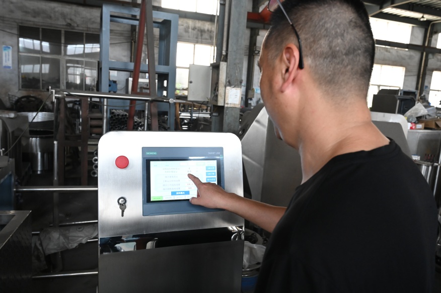 A technician is operating a high-speed granulator.