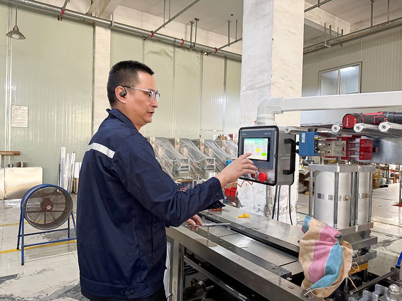 Ein Finetech-Techniker stellt die Arbeitsparameter der Blisterverpackungsmaschine ein