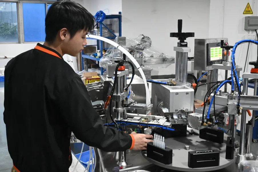 Worker is Adjusting the Tube Filling Machine