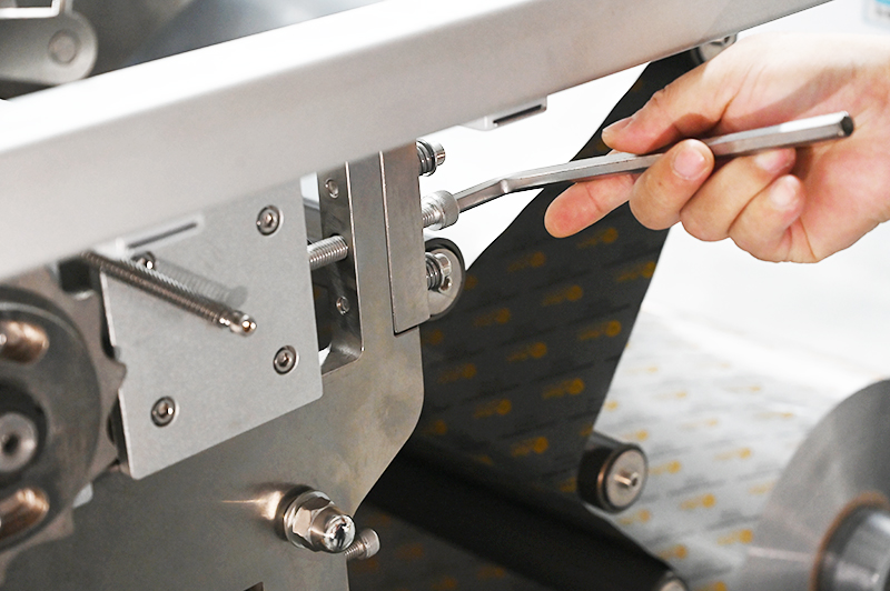 A technician is debugging a tablet strip packaging machine.