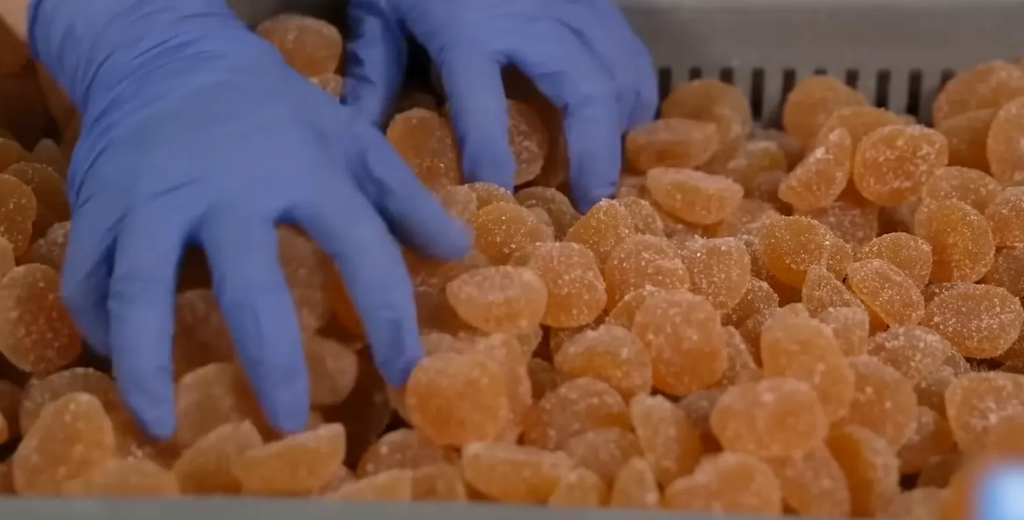 Die Gummibärchen manuell auf Formfehler prüfen.