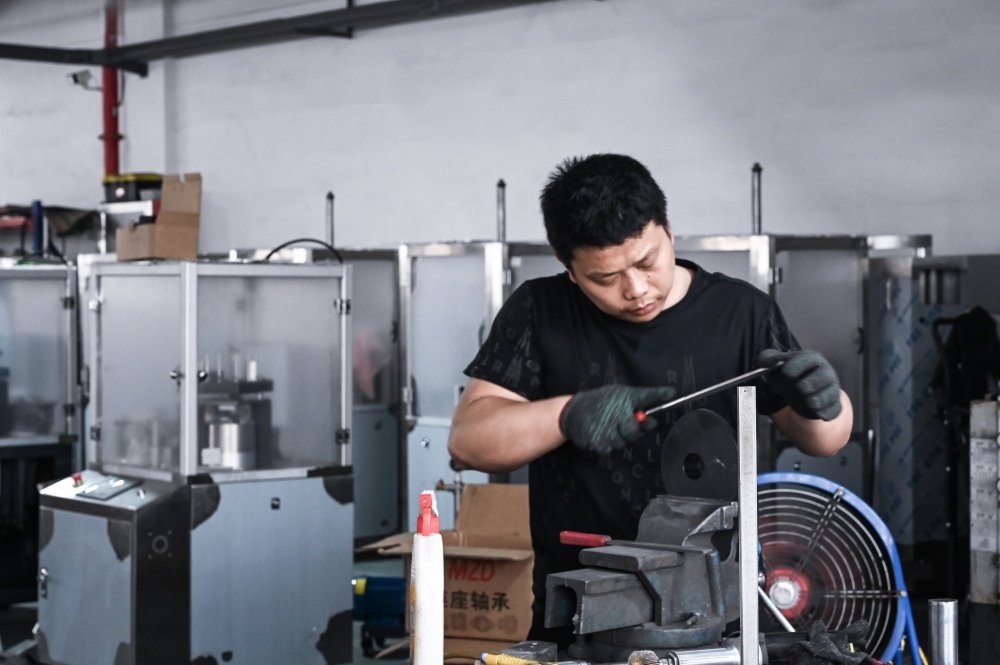 Packaging Machine China: Are They Actually Any Good? 4 Chinese Worker Assembling Packaging Machinery