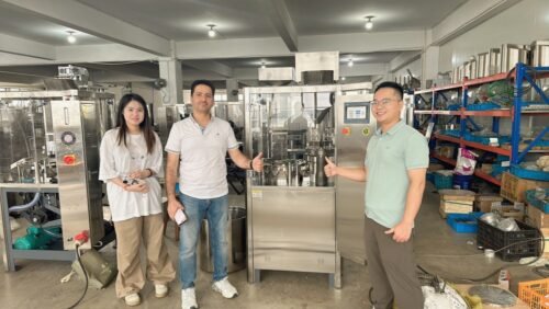 Group photo of the Syrian client and the Finetech team in front of the NJP‑1200 capsule filling machine.